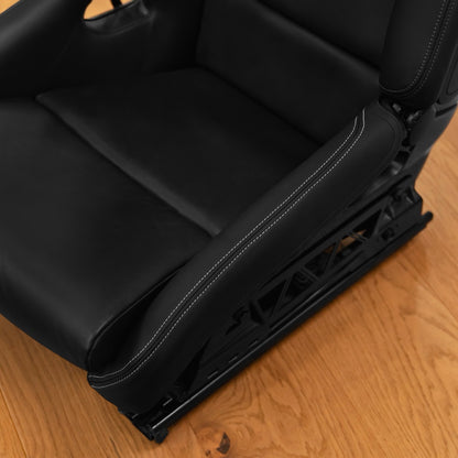 Top view of a black leather bolster protector installed along the side bolster of a Porsche 997 folding bucket seat
