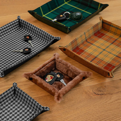 Collection of handmade Porsche leather valet trays in green tartan, houndstooth, orange plaid and brown shearling with Porsche keys, in different sizes